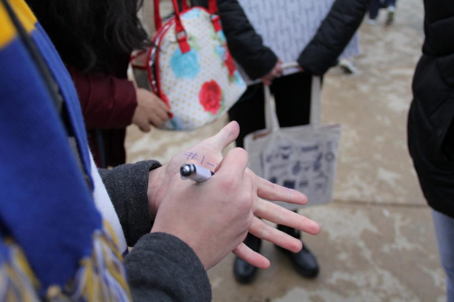 Vicki Agrella, sophomore, writes a reminder on her hand after school. Agrella says the rumors she hears about ink damaging her health never give her pause. 