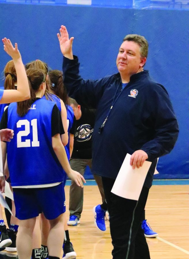 Christopher Bennett, girls basketball coach and economics teacher, gives a high five to one of his players after a practice. Bennett has been on the coaching staff for 22 years and has over 200 career wins.