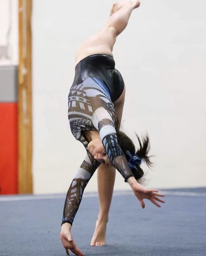 Julia McDevitt, senior, springs into part of her floor routine, trying to get the best score she can. The varsity gymnastics team hopes to perform wells in the upcoming state series on February 21st and 22nd.