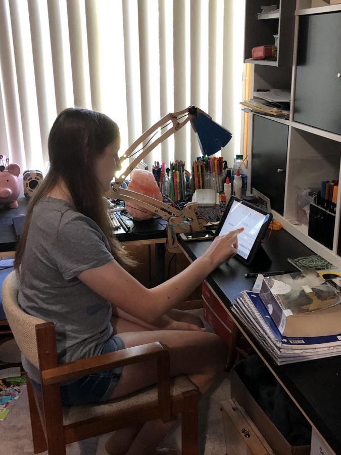 Emma Harper, freshman, gets ready for a day of e-learning at home. By staying at home, learning for some freshmen has been full of new obstacles to face. 