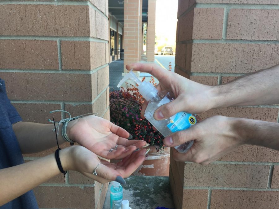 A manager offers hand sanitizer to his employee before work. As the COVID-19 pandemic continues to plague the community and the nation, one way businesses are keeping employees safe by keeping sanitizer in stock at all times.