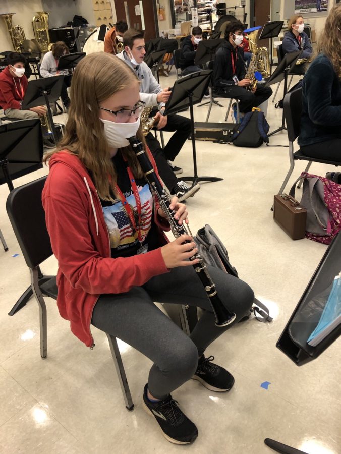 Grace Trumbull, junior hybrid learner, plays her clarinet in band by having a hole through her mask. Trumbull says her choice to return back to school was influenced “mainly because of choir and band. Singing and playing an instrument have been a disappointment during e-learning because I have to practice by myself.”