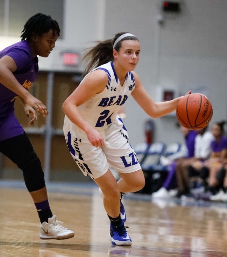 Erin Stewart, junior, dribbles the ball up the court in hopes of getting a basket. Stewart has been playing basketball since she was very young, and continues to strive to be better. 