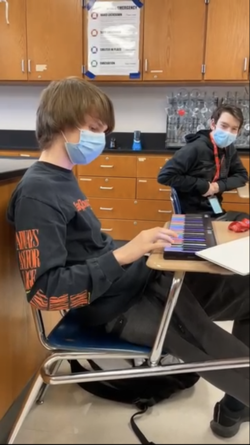 Nikko Gajowniczek, junior, entertains himself by playing piano in his AP Chemistry class. However, Gajowniczek says this distraction pales in comparison to the distractions at home that in-person school has helped him get away from. 