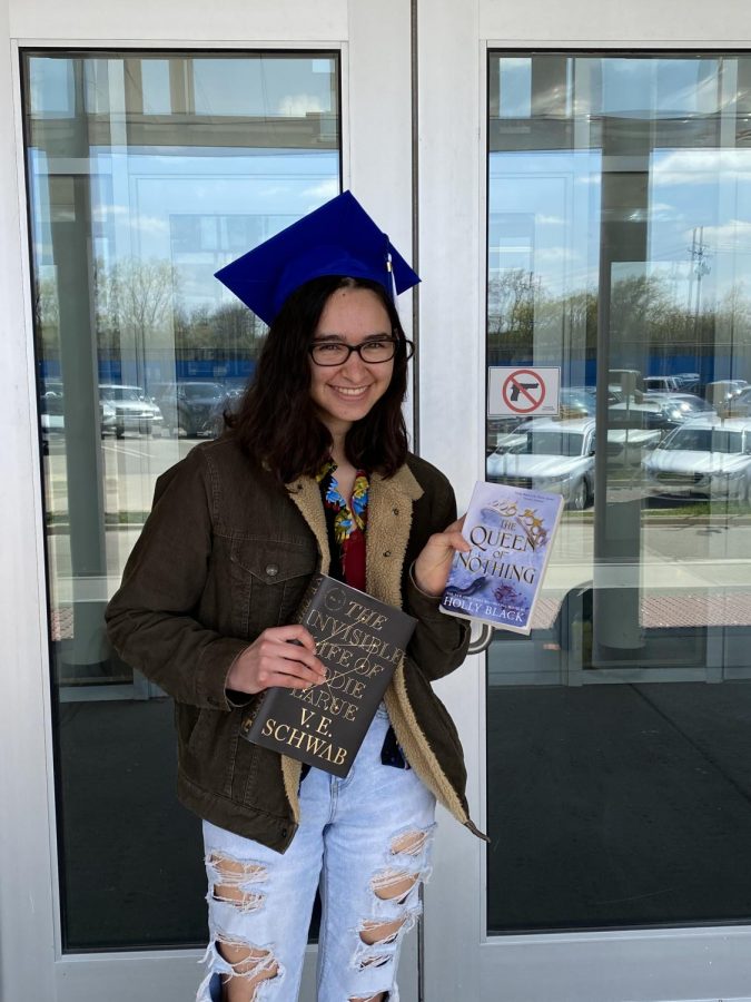 Bella Brunke, senior, holds up two of her favorite books, “The Invisible Life of Addie Larue” and “The Queen of Nothing”