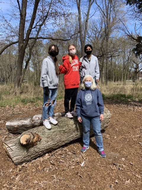 Members of the REACT club smile as they work on helping the forests in Lake Zurich. They remove an invasive species from the oak trees surrounding LZHS.