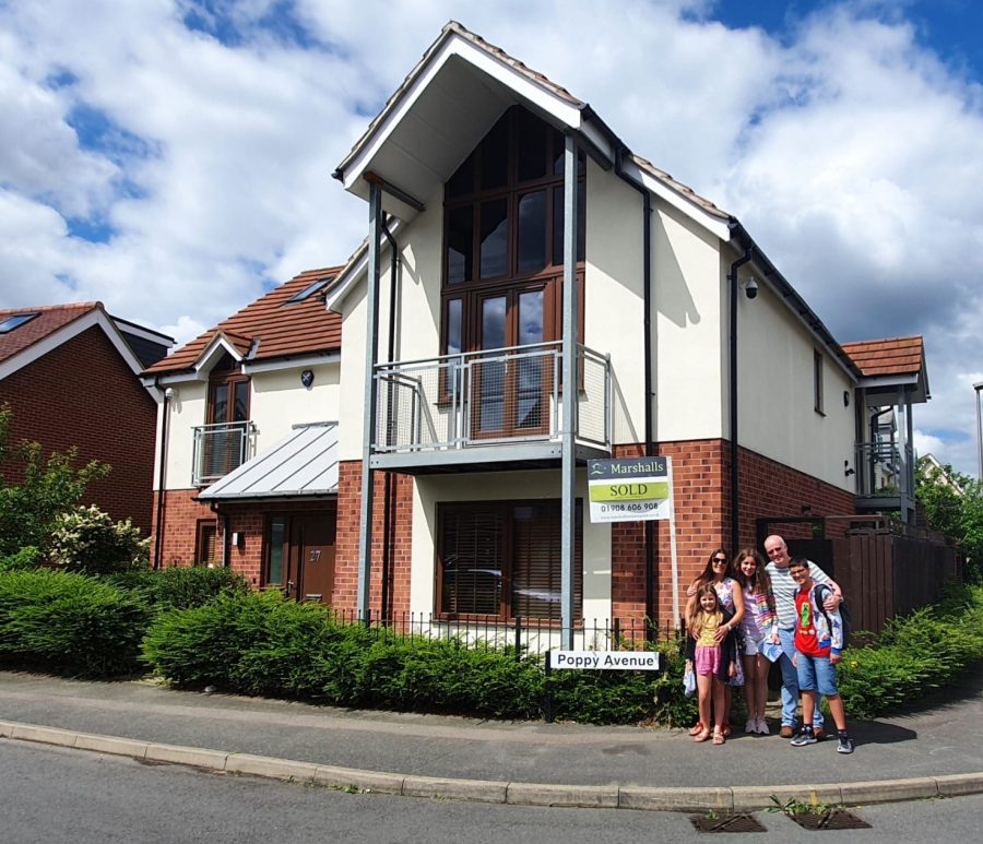 Michaella Walker, freshman, and her family stand by her previous house in Milton Keynes, England.