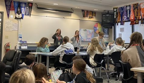 Ava Malin and Delaney Petrow, seniors, teaching signs at the ASL club to students attending the before school meeting. 