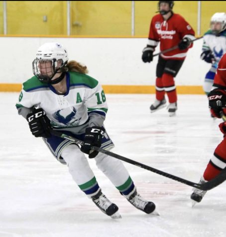 Bourbon plays at a hockey game on her female hockey team.