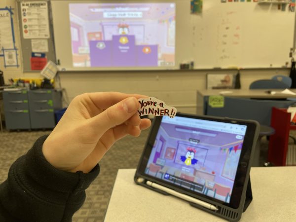 A student receives a prize for winning a Kahoot game in class. Some teachers feel it is important to give out stickers to reward participation, rather than just academic achievements, such as tests and homework assignments.