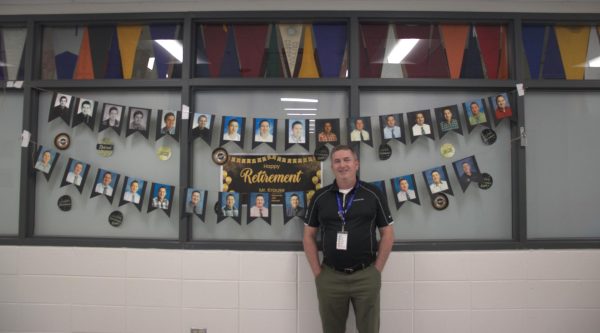 Carl Krause, college and career counselor stands outside the college and career center, decorated with yearbook pictures from all his years at LZ.