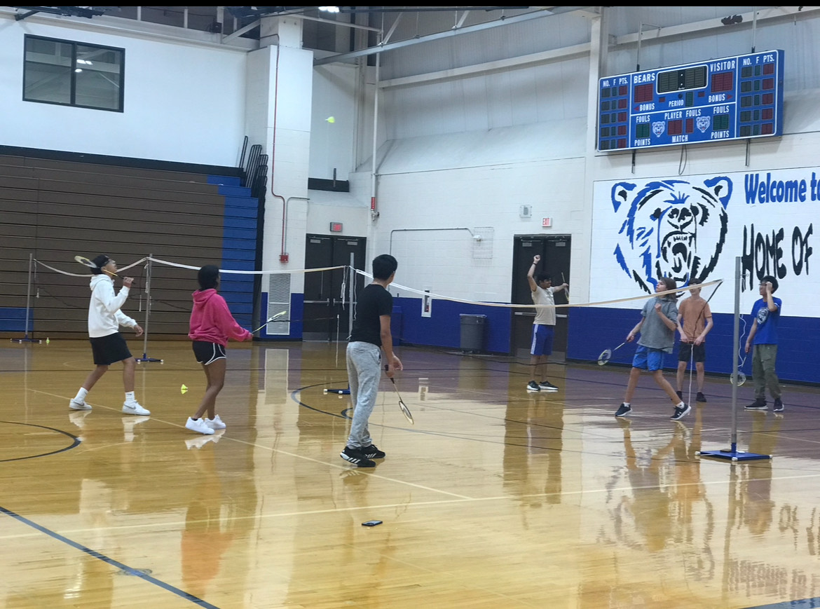 Students playing badminton, the club is open to all skill levels and is an opportunity for students to be social with friends.