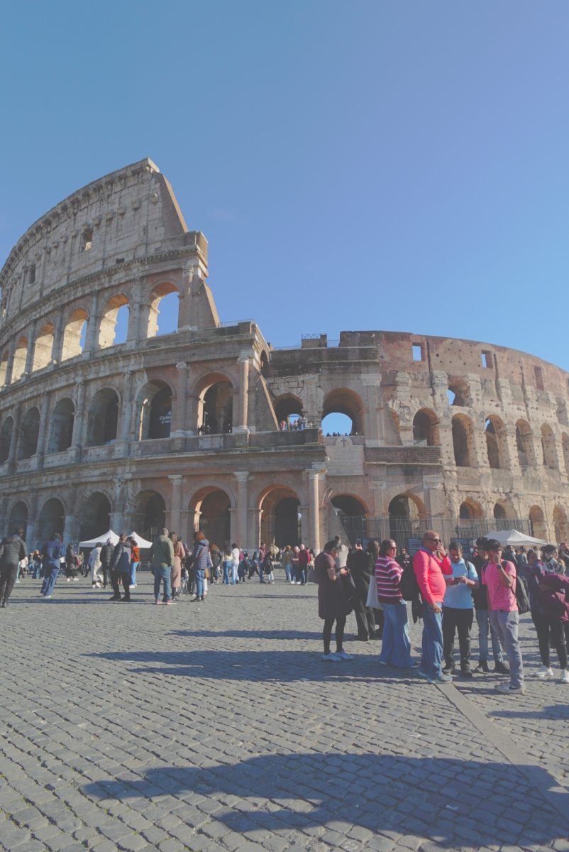 Tourists stand outside of the Colosseum located in the heart of Rome.