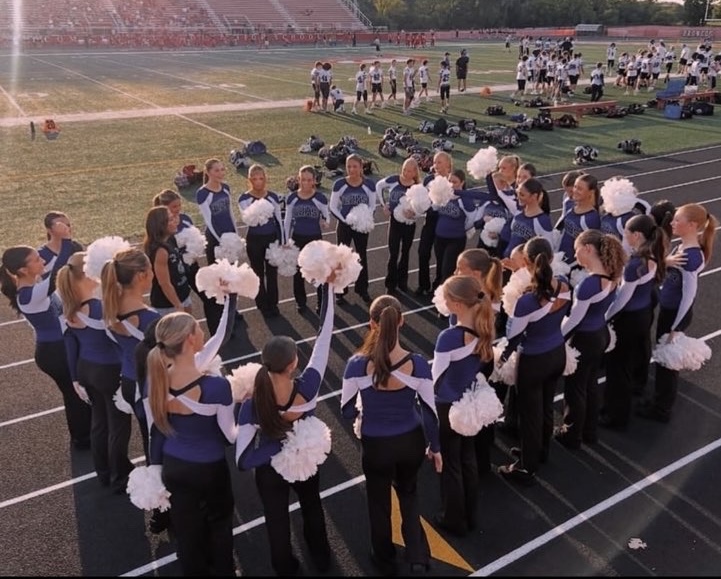 The poms team gathered in a huddle before they performed at half time, sharing their focus and energy before they took the floor. (Used by permission of Alina Zaro) 