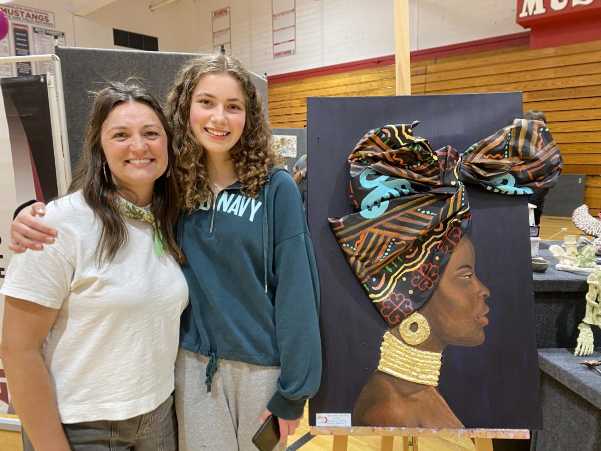 Kristen LaJeunesse and Michaella Walker at an art show with her piece that represents the women of South Africa (Photo used with permission by Kristen LaJeunesse).